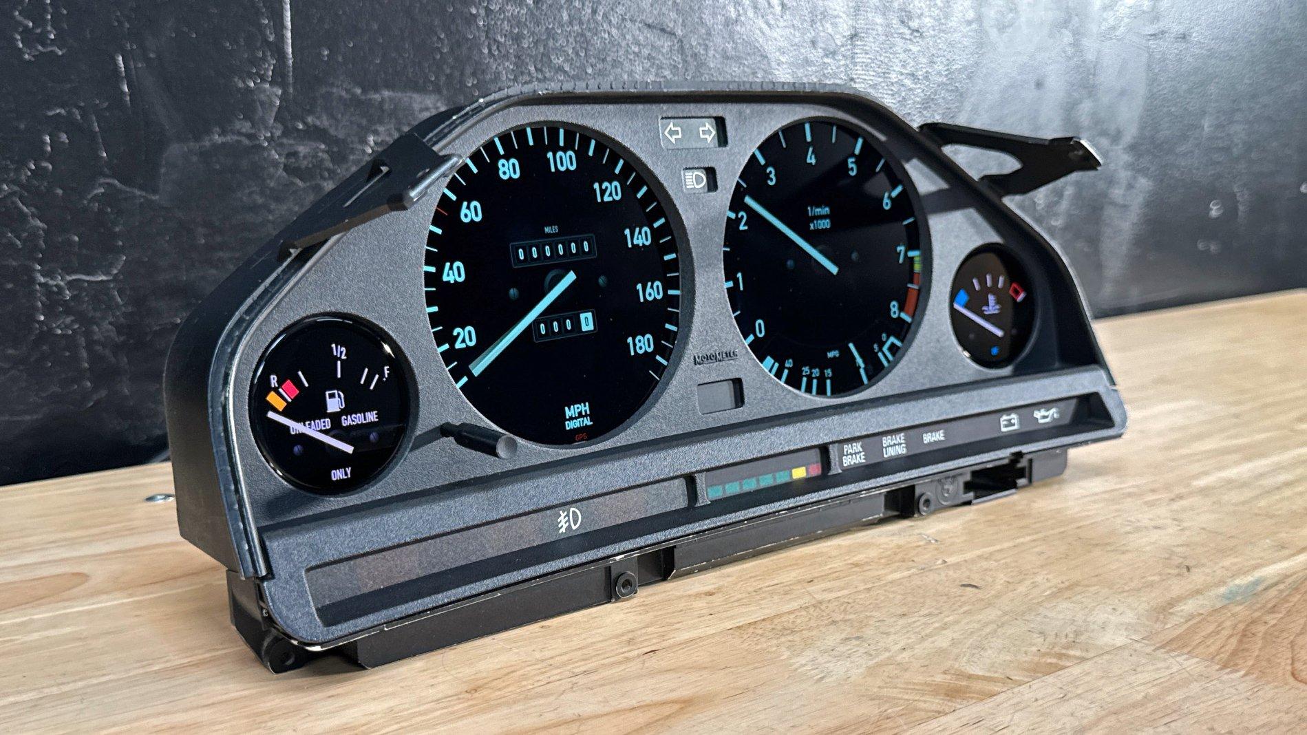 The E30 digital cluster prototype photographed on the workshop bench for The Drive, with all four displays visible